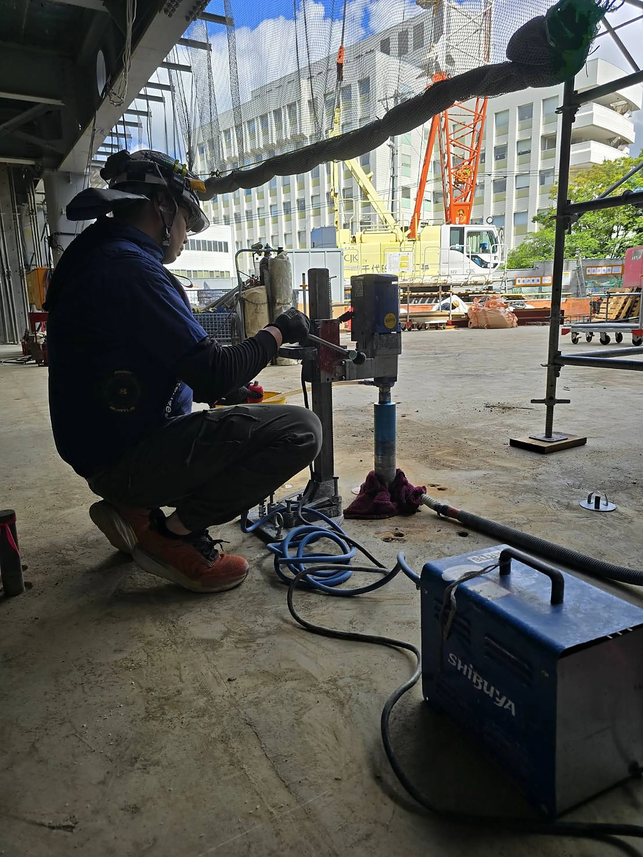 An ARTIS worker performing concrete core drilling at a construction site