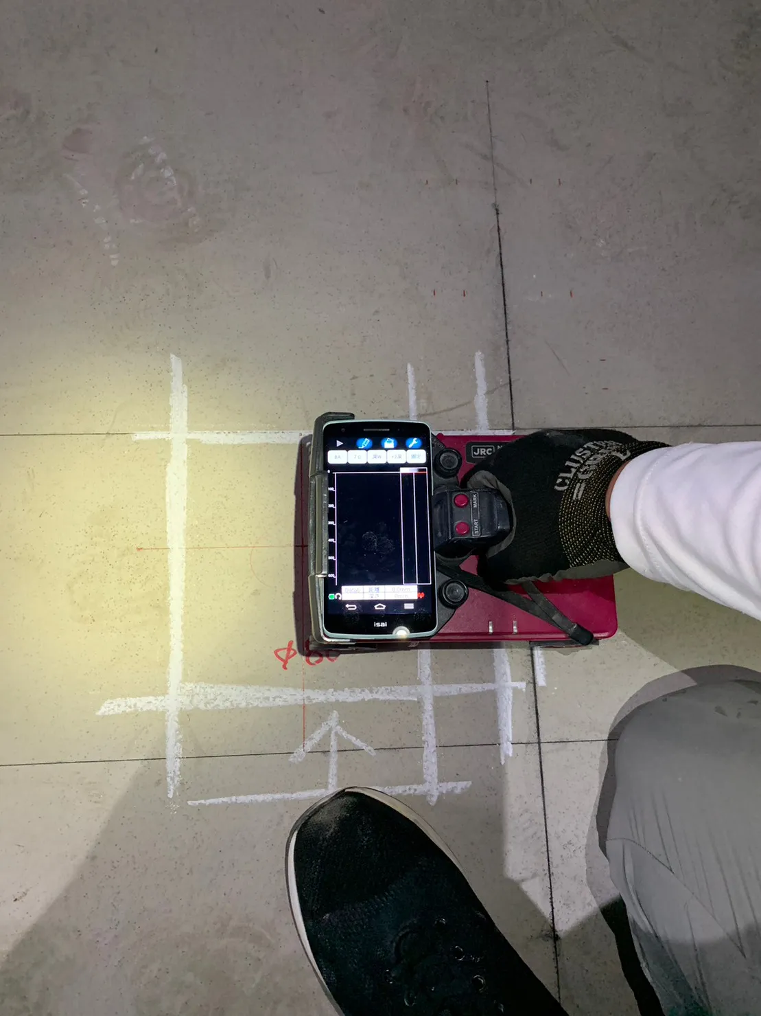 ハンディ型RCレーダーで床コンクリートの内部を探査する様子